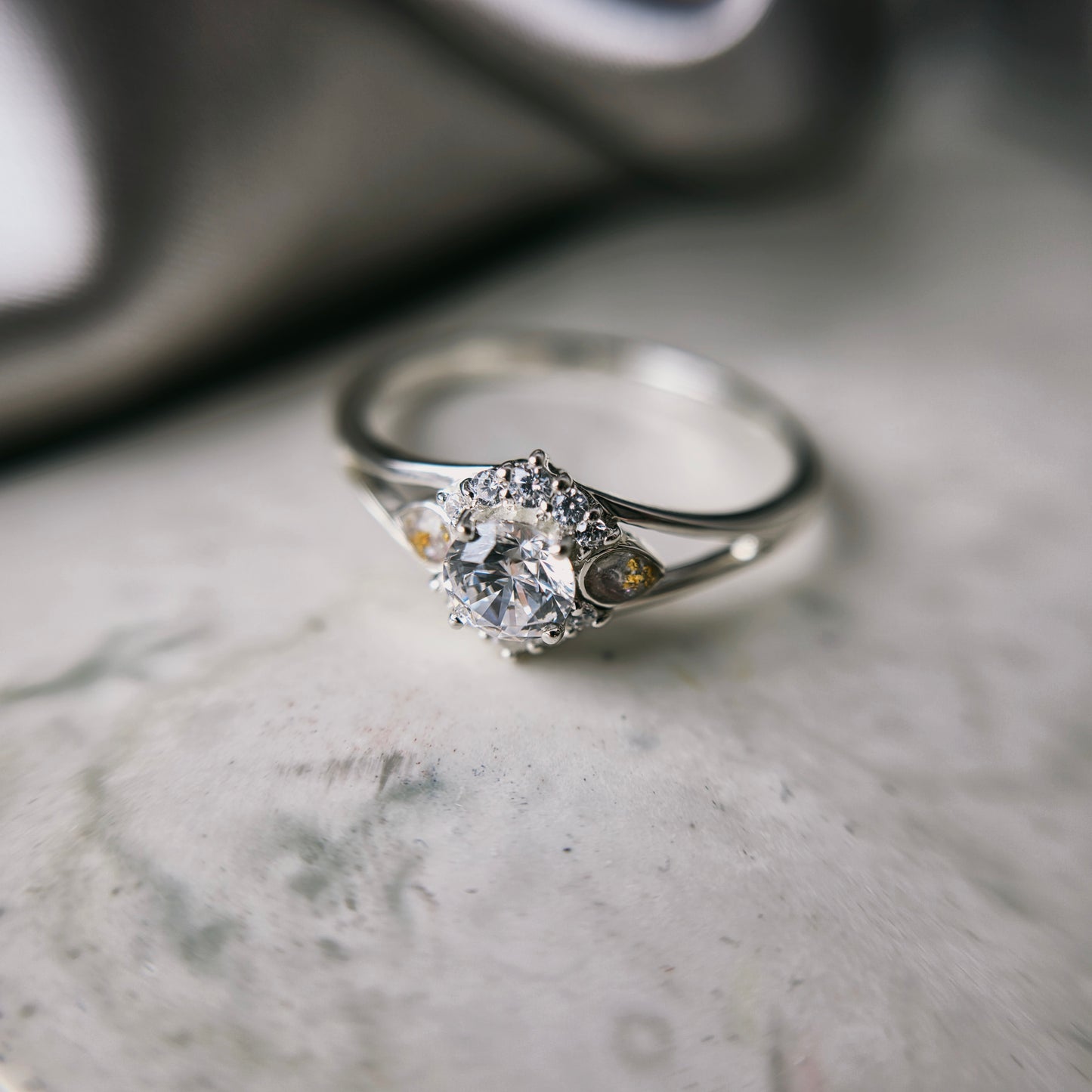 Silver ring with a diamond on a marble surface