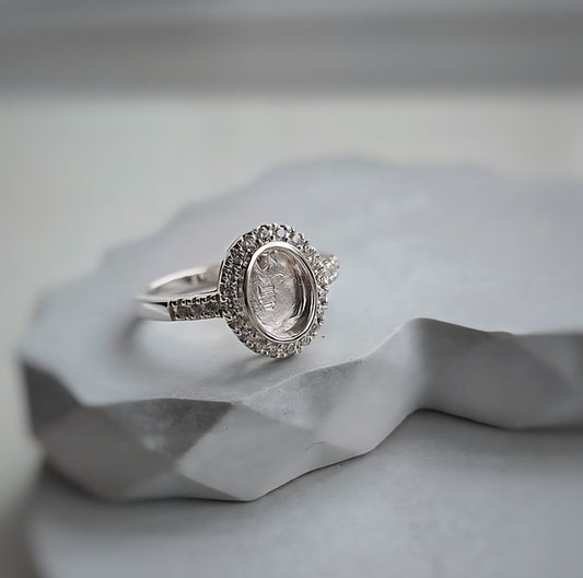 Silver ring with a diamond on a textured gray surface