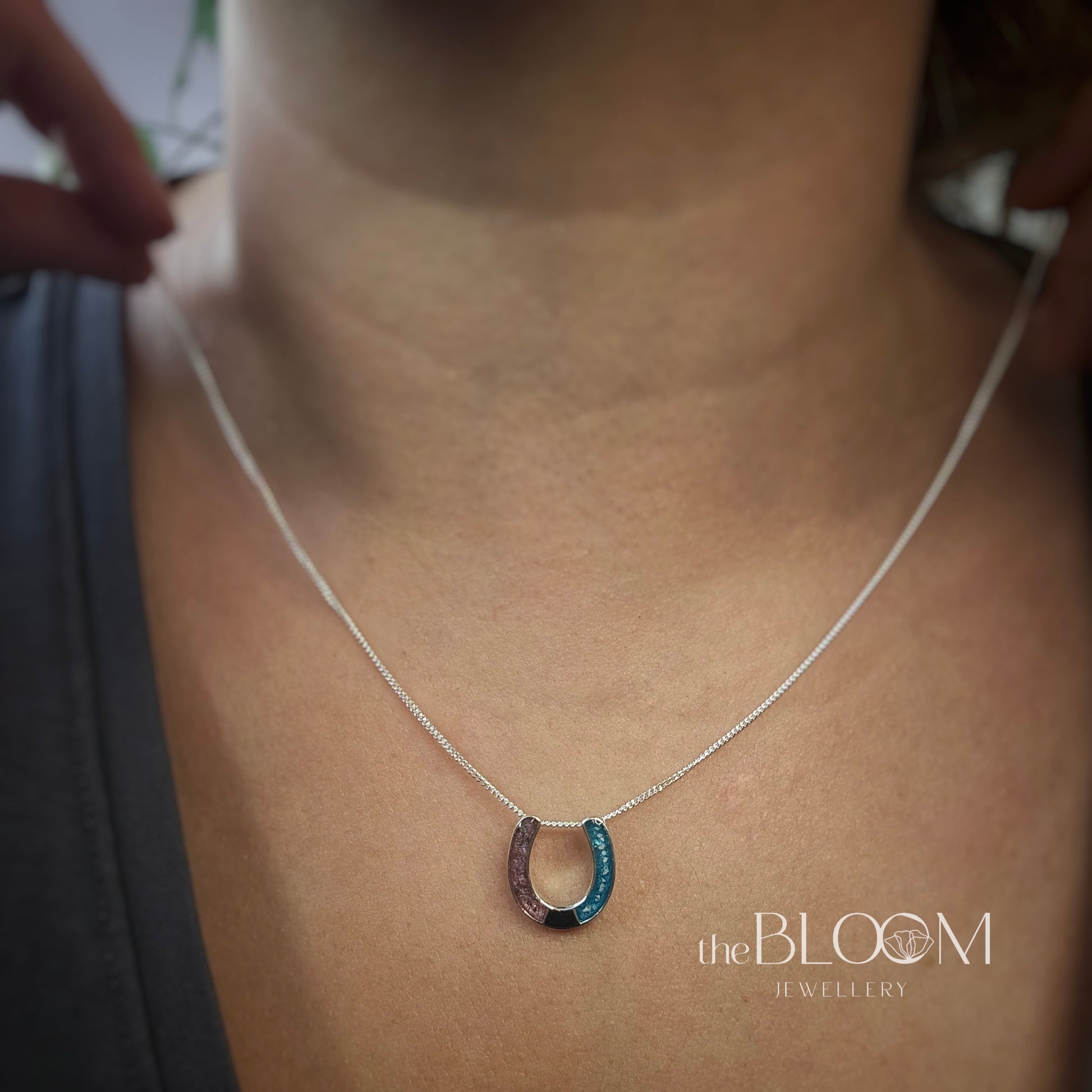 Necklace with a keepsake horseshoe pendant on a person's neck