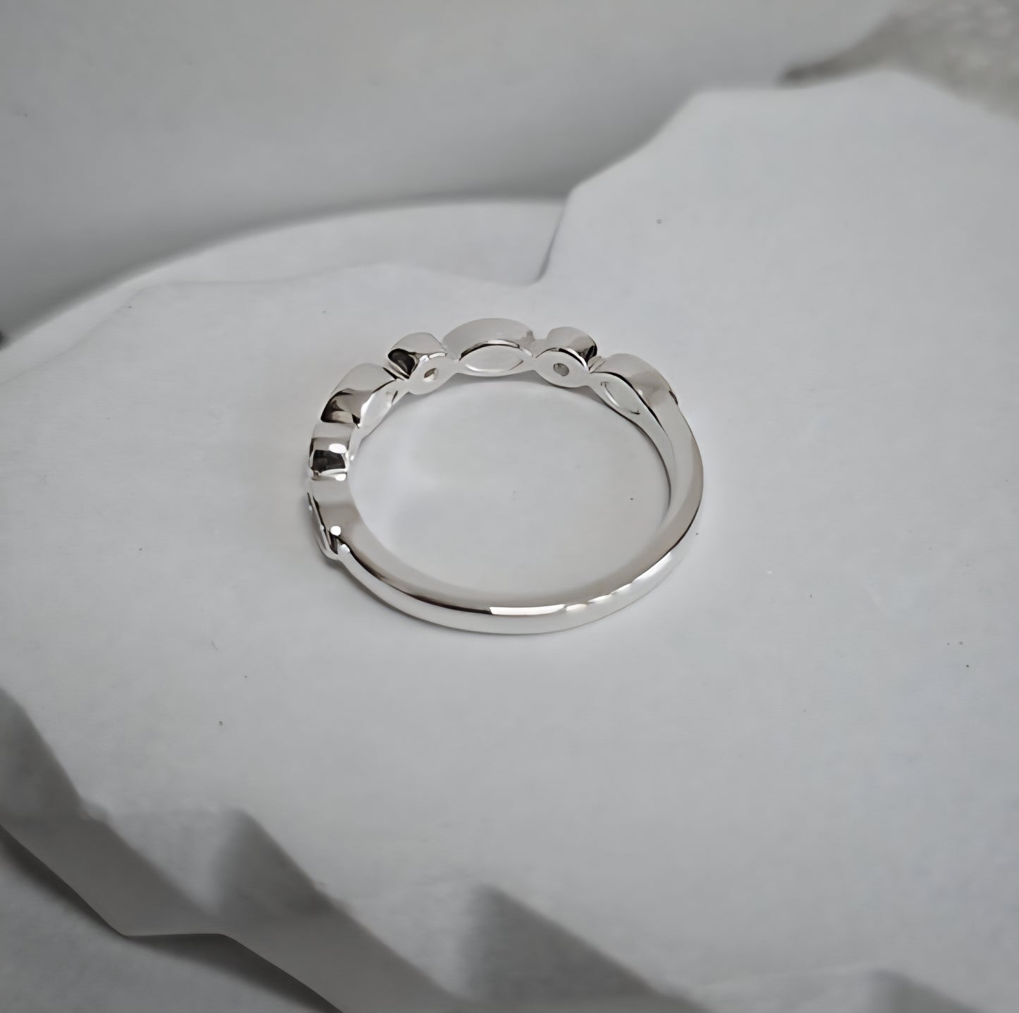 Silver ring on a soft white fabric background