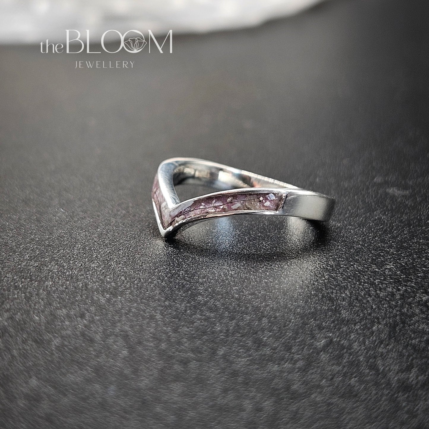 Silver ring on a dark textured surface with 'the BLOOM JEWELLERY' logo.
