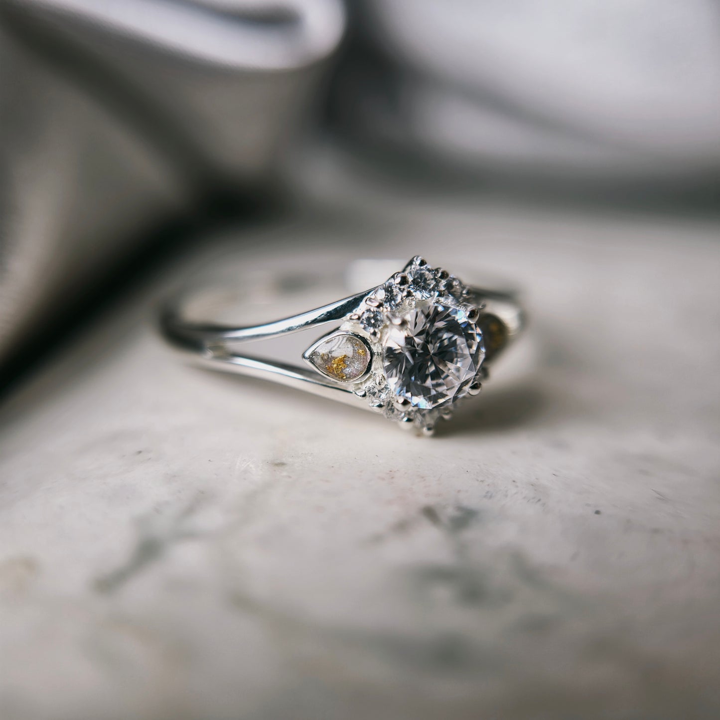 Silver ring with a diamond on a marble surface