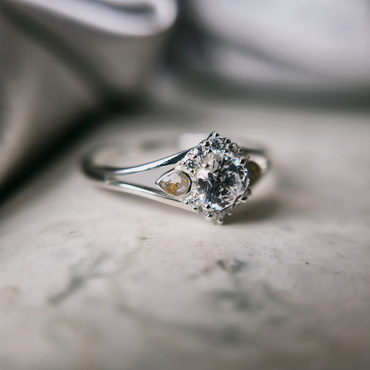 Silver ring with a diamond on a marble surface