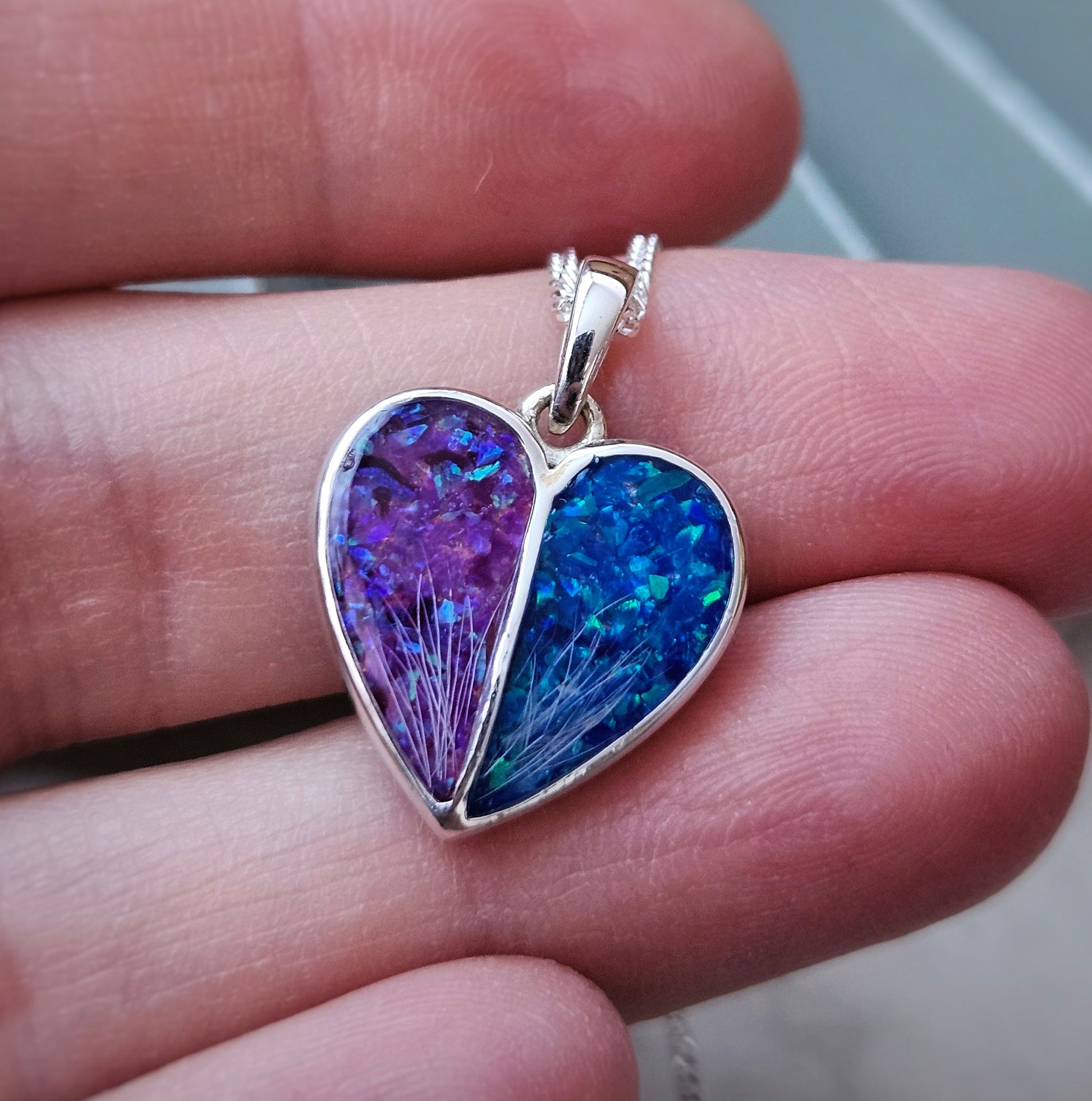 Heart-shaped pendant with purple and blue colors held between fingers