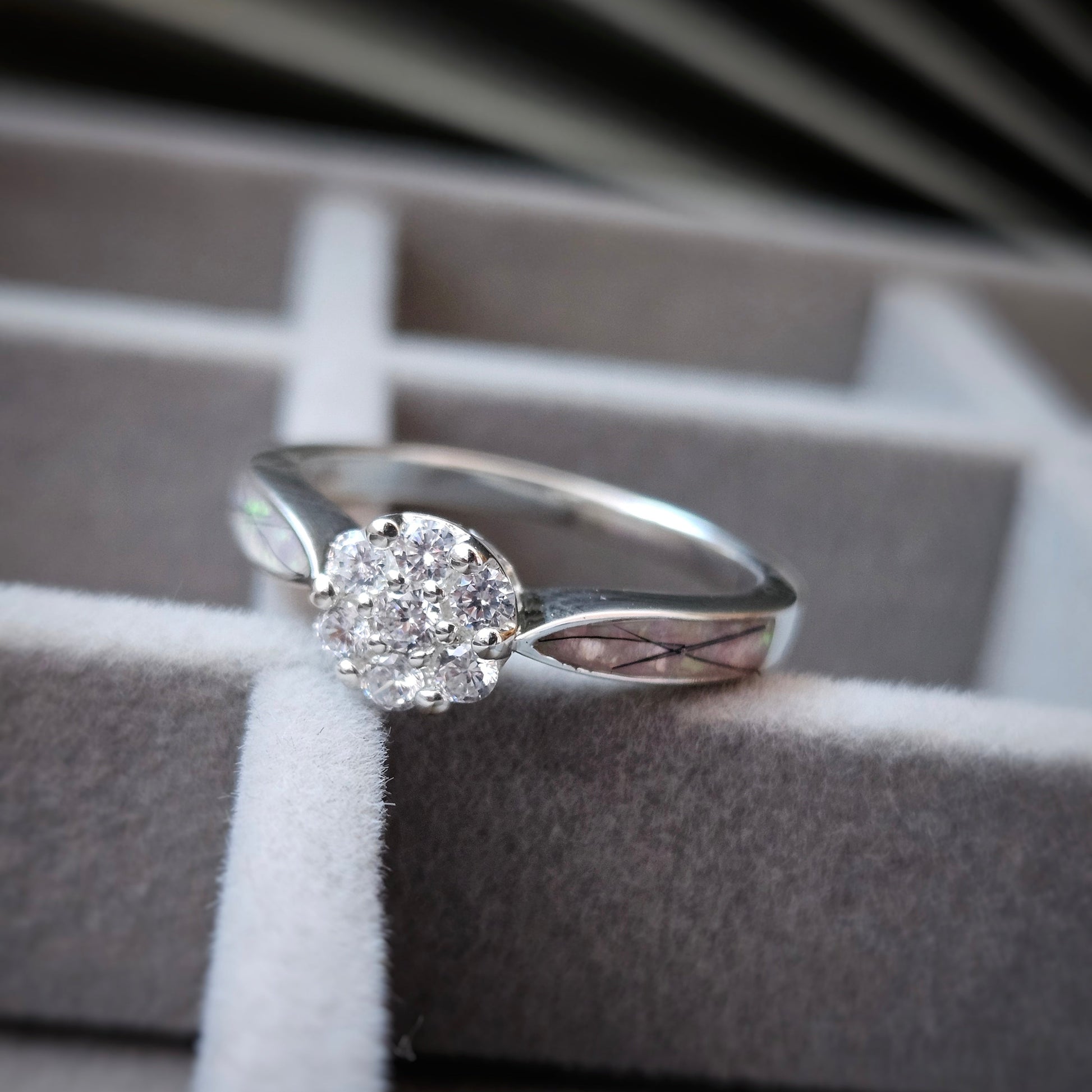 Silver ring with a diamond on a gray fabric surface