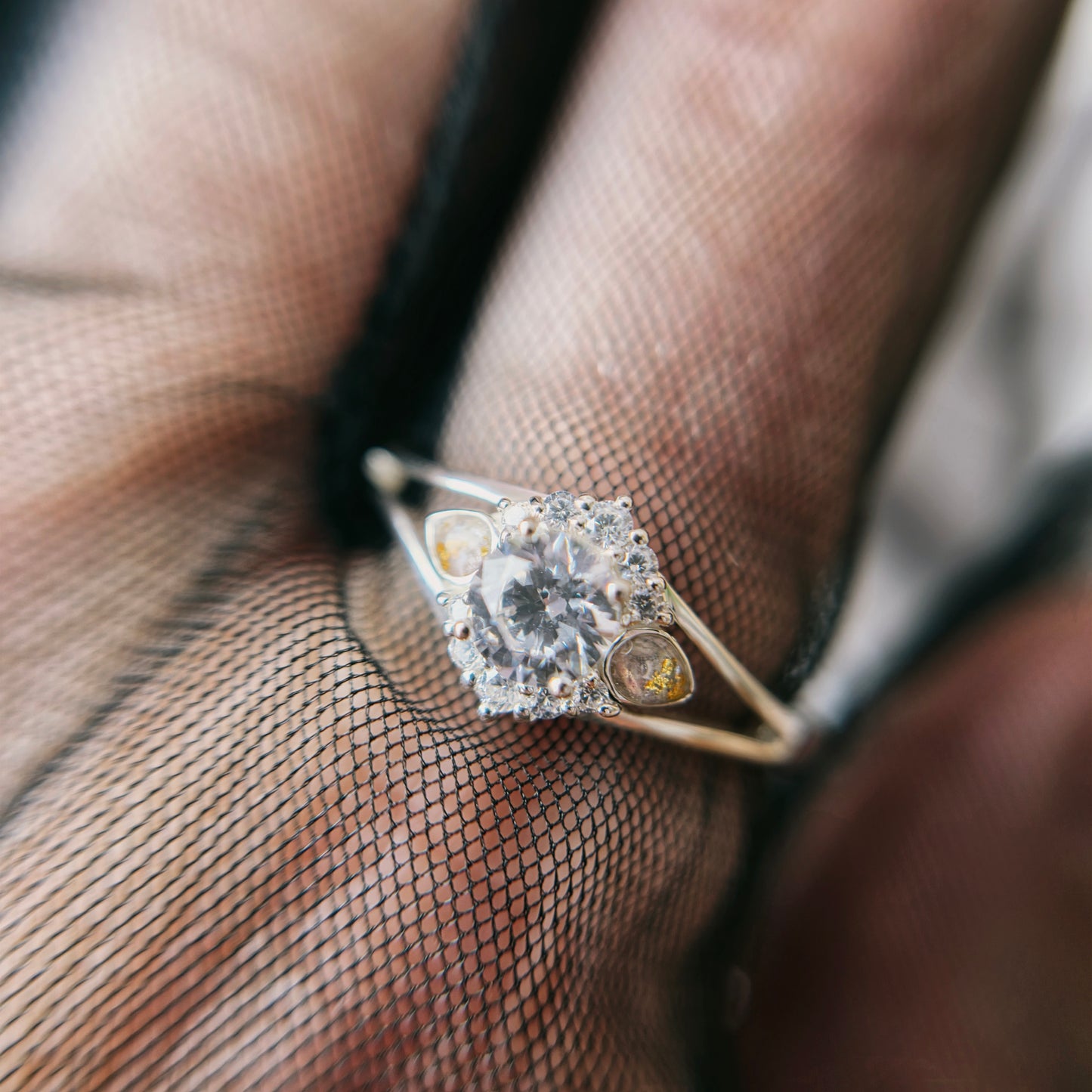 Silver ring with a diamond on a hand wearing sheer black gloves
