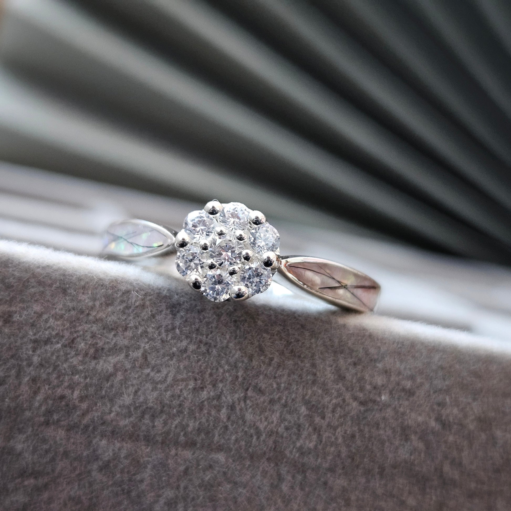 Silver ring with a diamond-like center on a textured surface