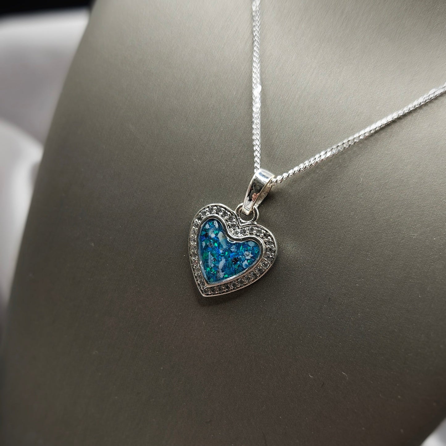 Heart-shaped necklace with blue gemstones on a dark background