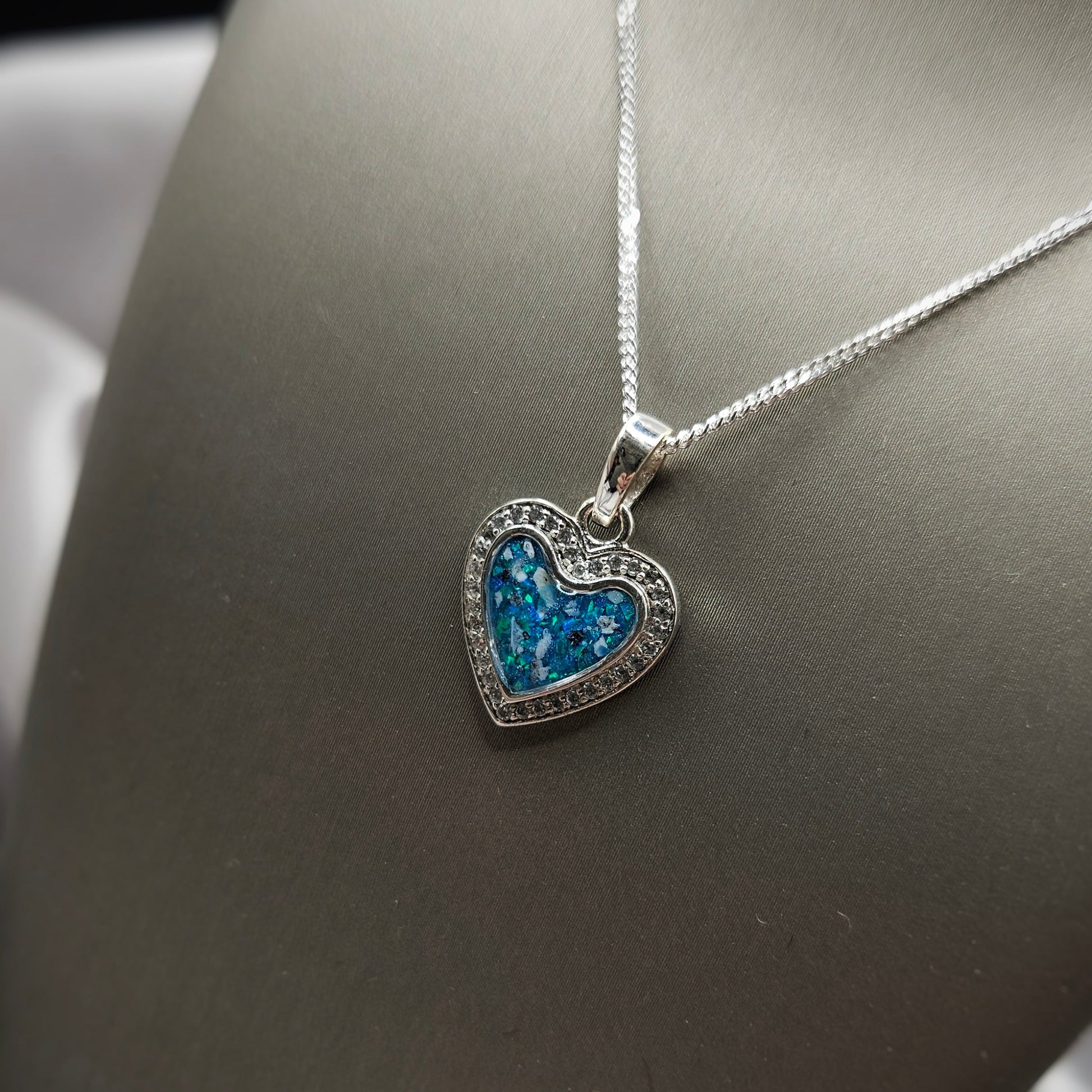 Heart-shaped necklace with blue gemstones on a dark background