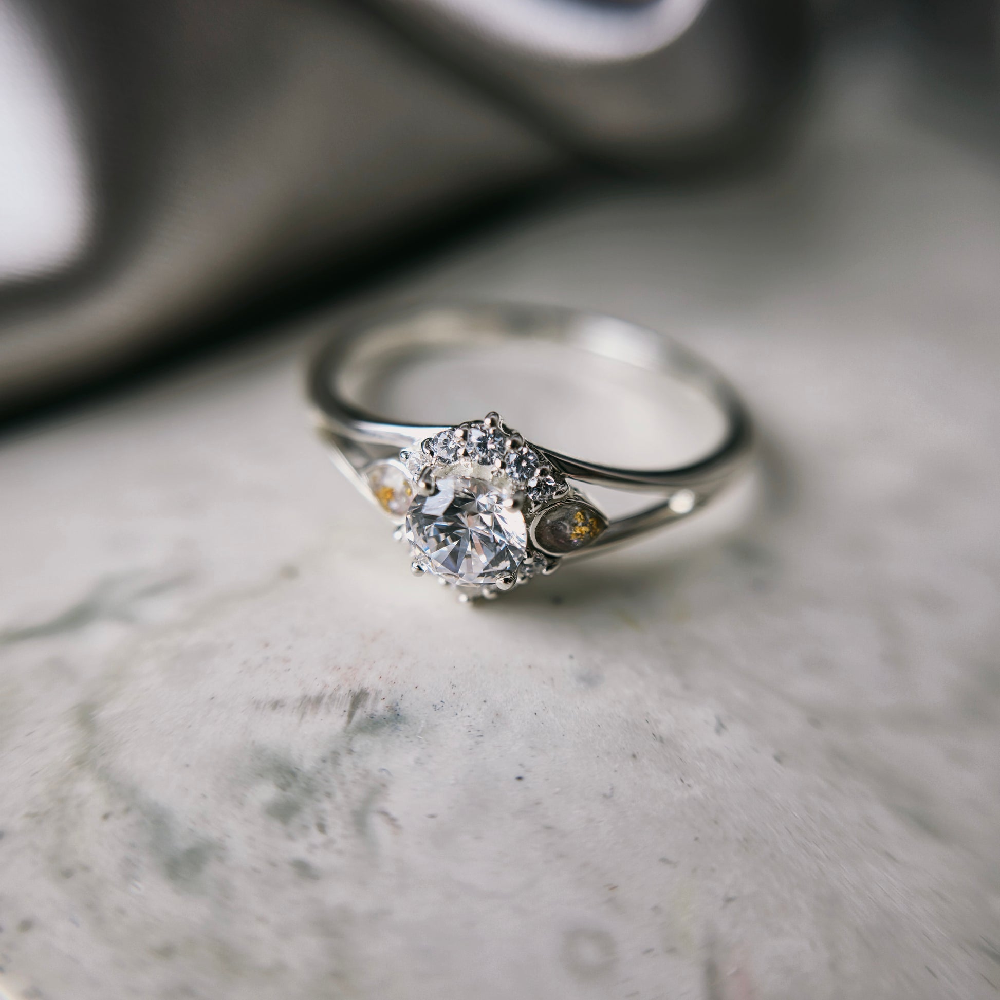 Silver ring with a diamond on a marble surface