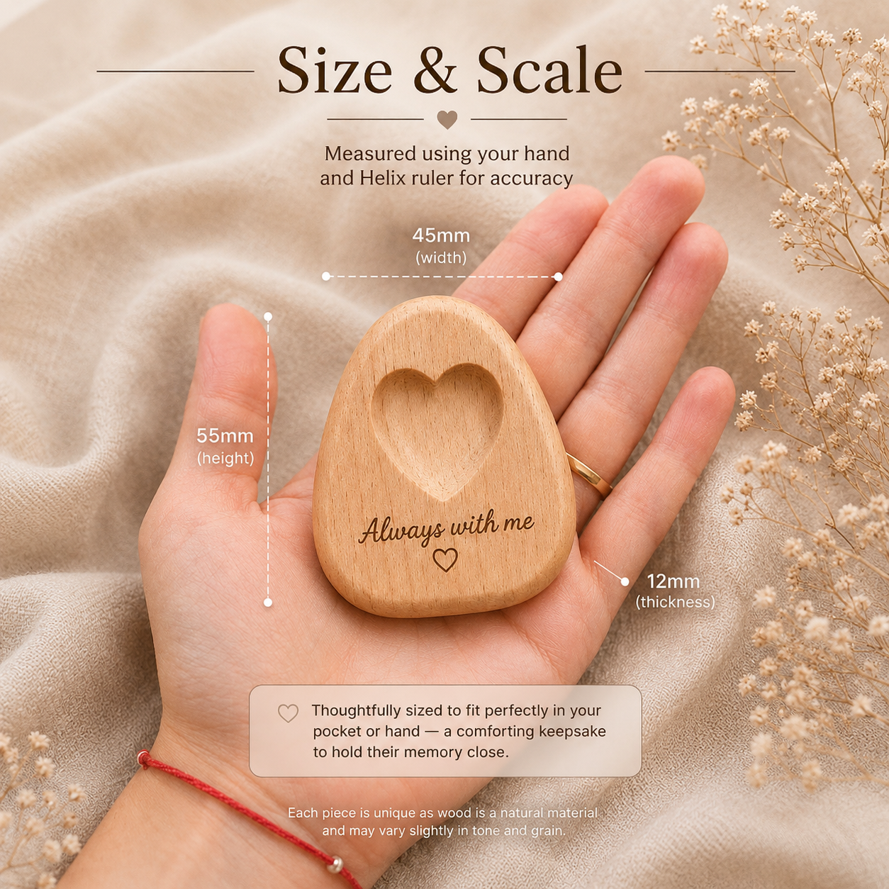 A wooden keepsake stone with a heart-shaped cutout and the engraved words 'Always with me' is held in a person's hand. The image includes size annotations showing 55mm height, 45mm width, and 12mm thickness, with a soft beige fabric background 