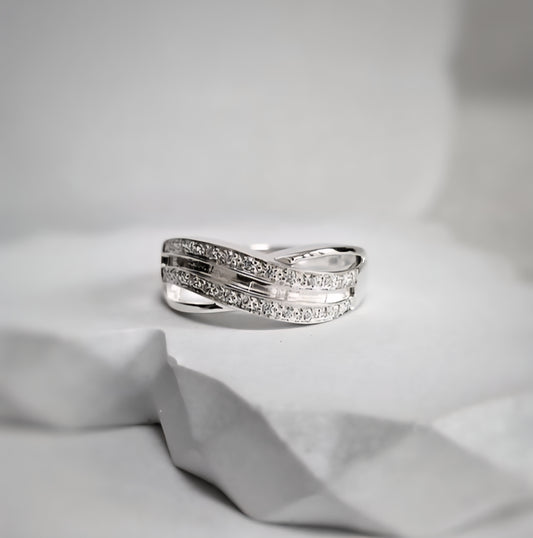 Silver ring with small diamonds on a light gray fabric background