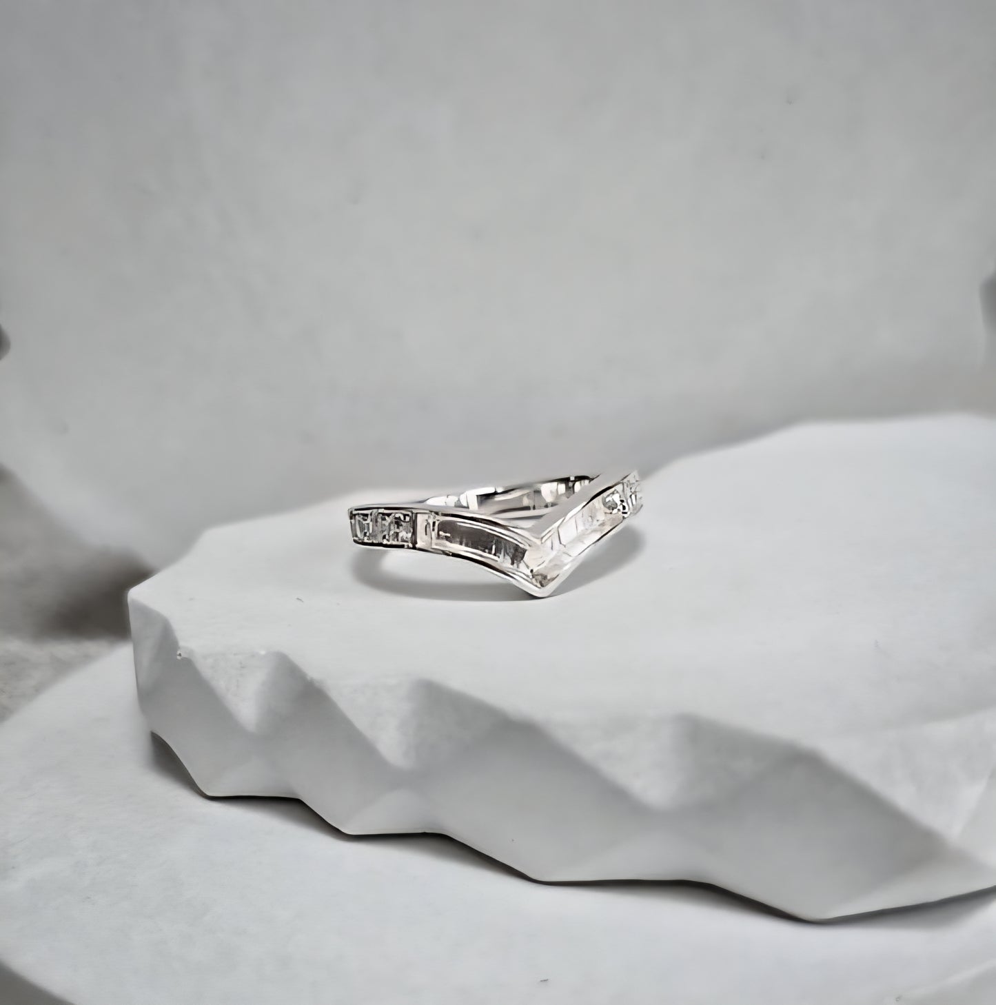 Silver ring with diamonds on a textured gray surface