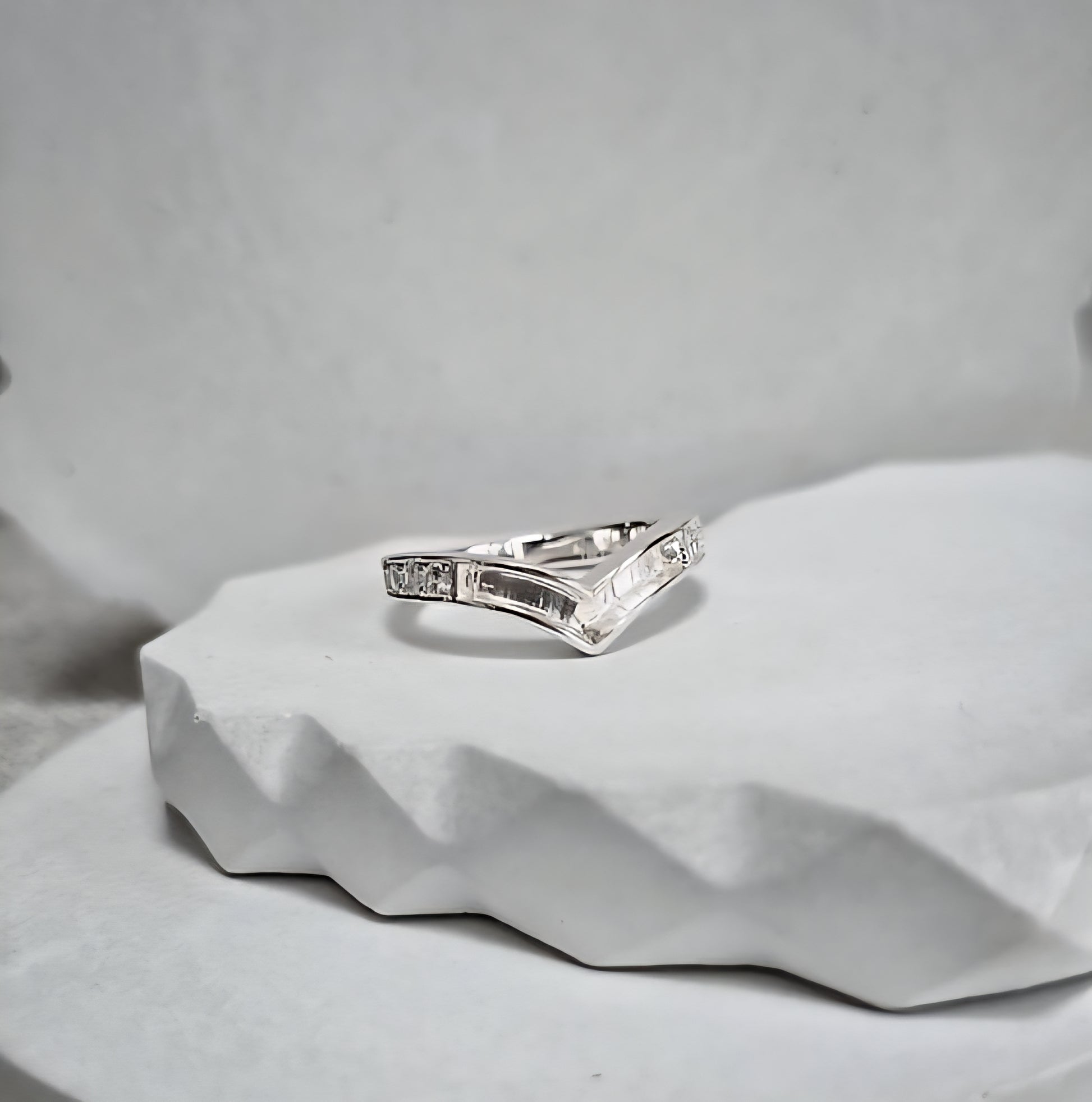 Silver ring with diamonds on a textured gray surface