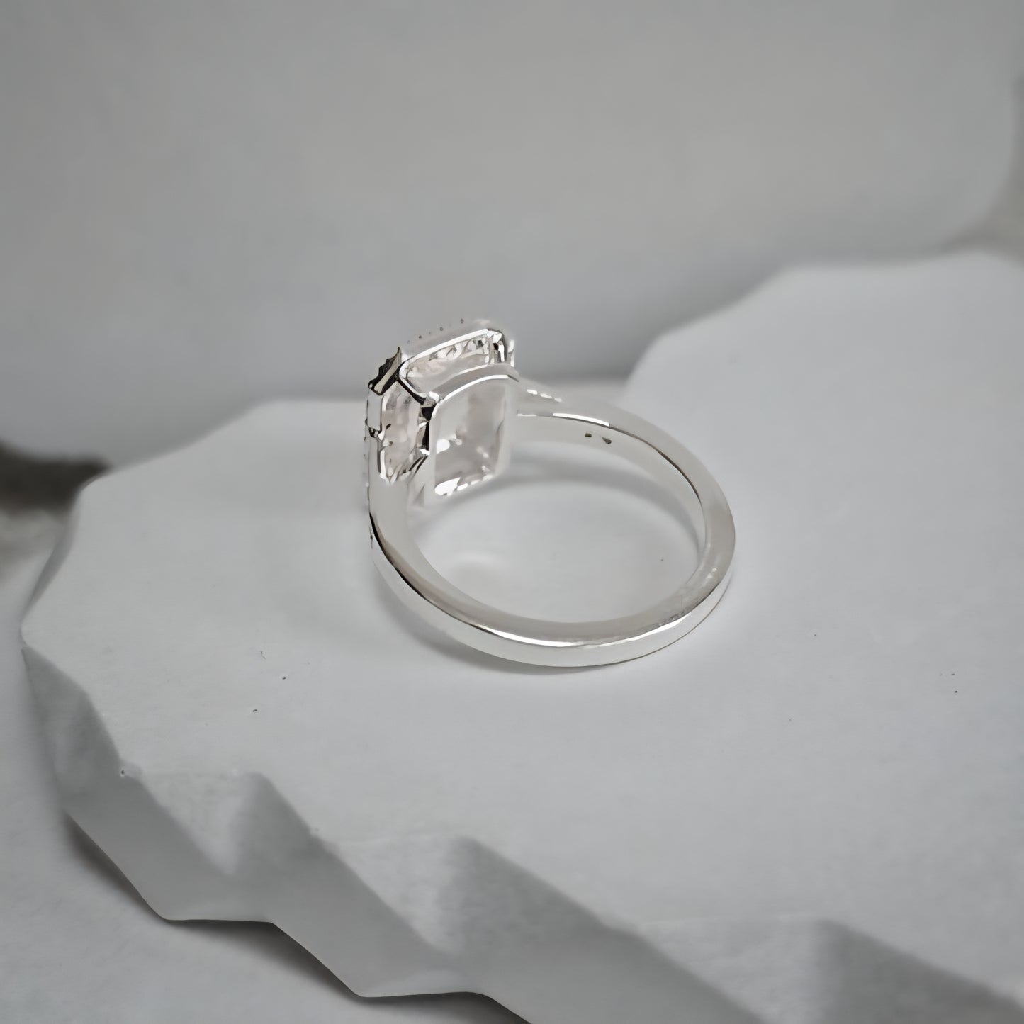 Silver ring with a diamond on a gray stone surface
