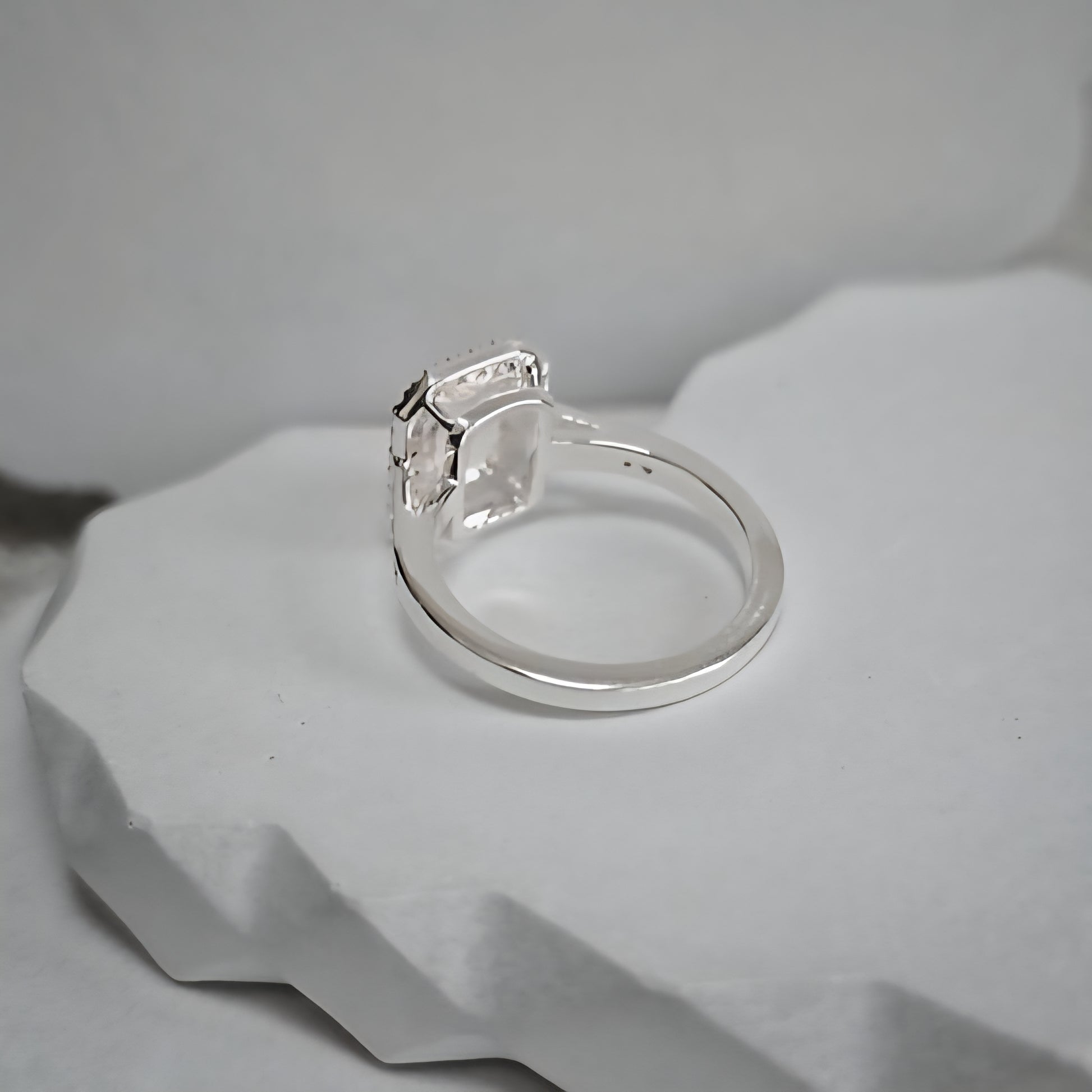 Silver ring with a diamond on a gray stone surface