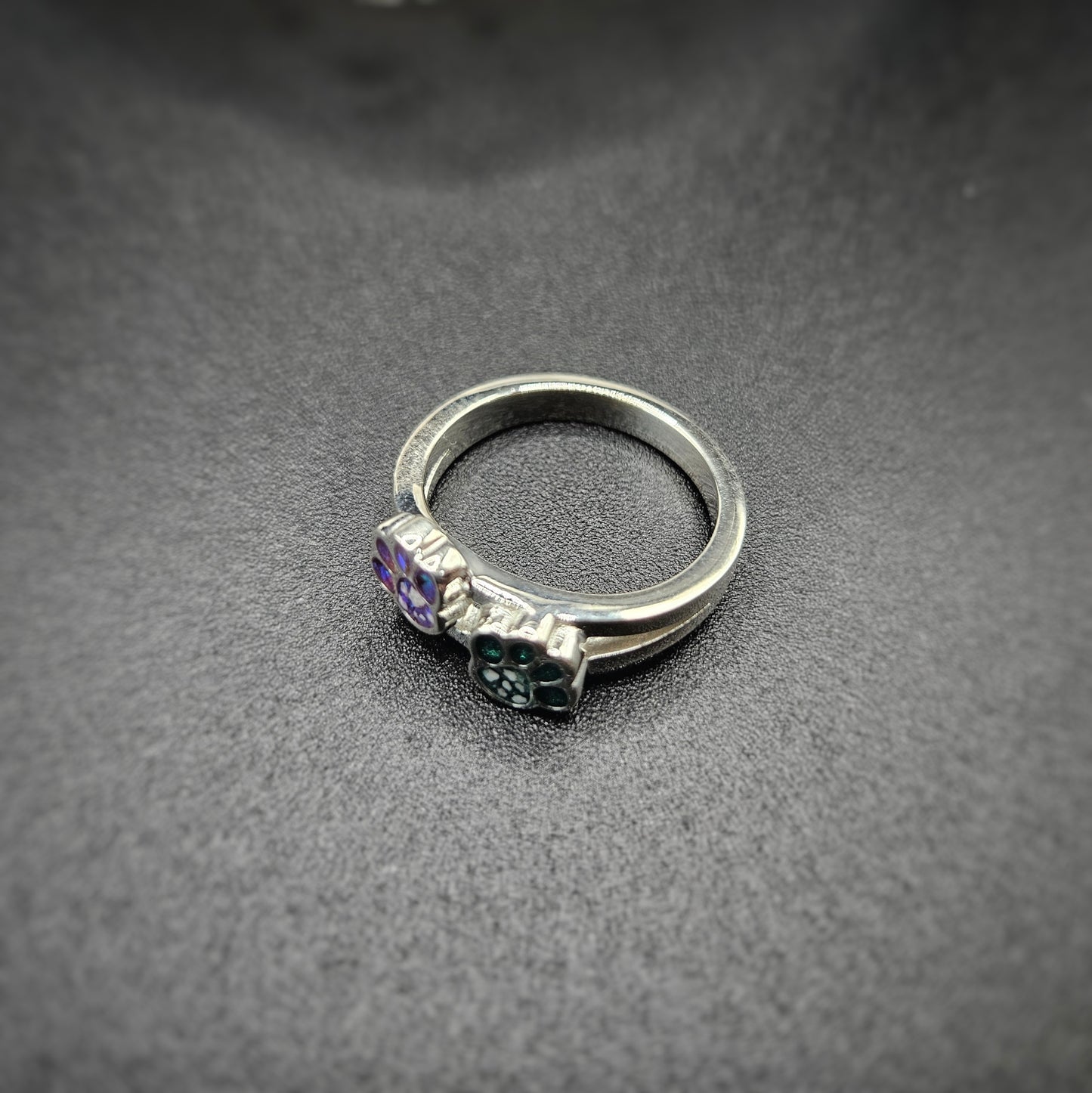 Silver ring with gemstones on a dark gray surface