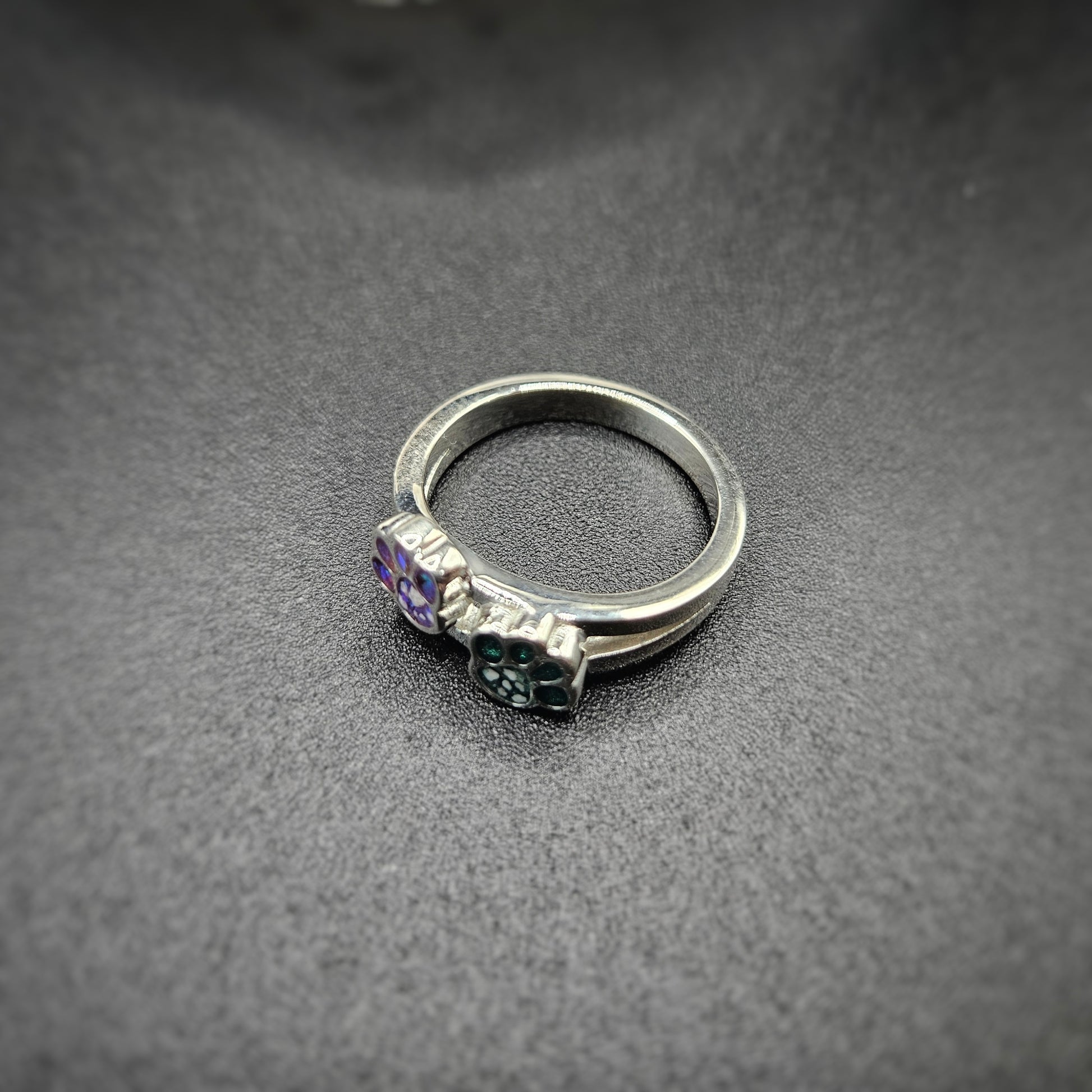 Silver ring with gemstones on a dark gray surface