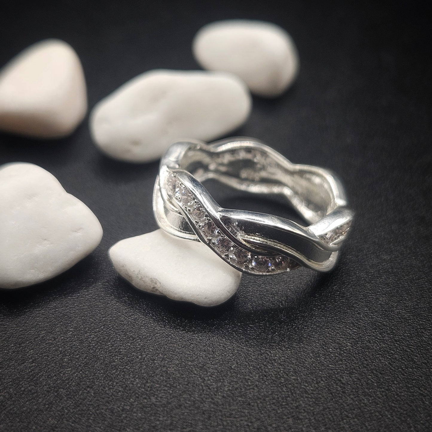 Silver ring with a textured design on pebbles