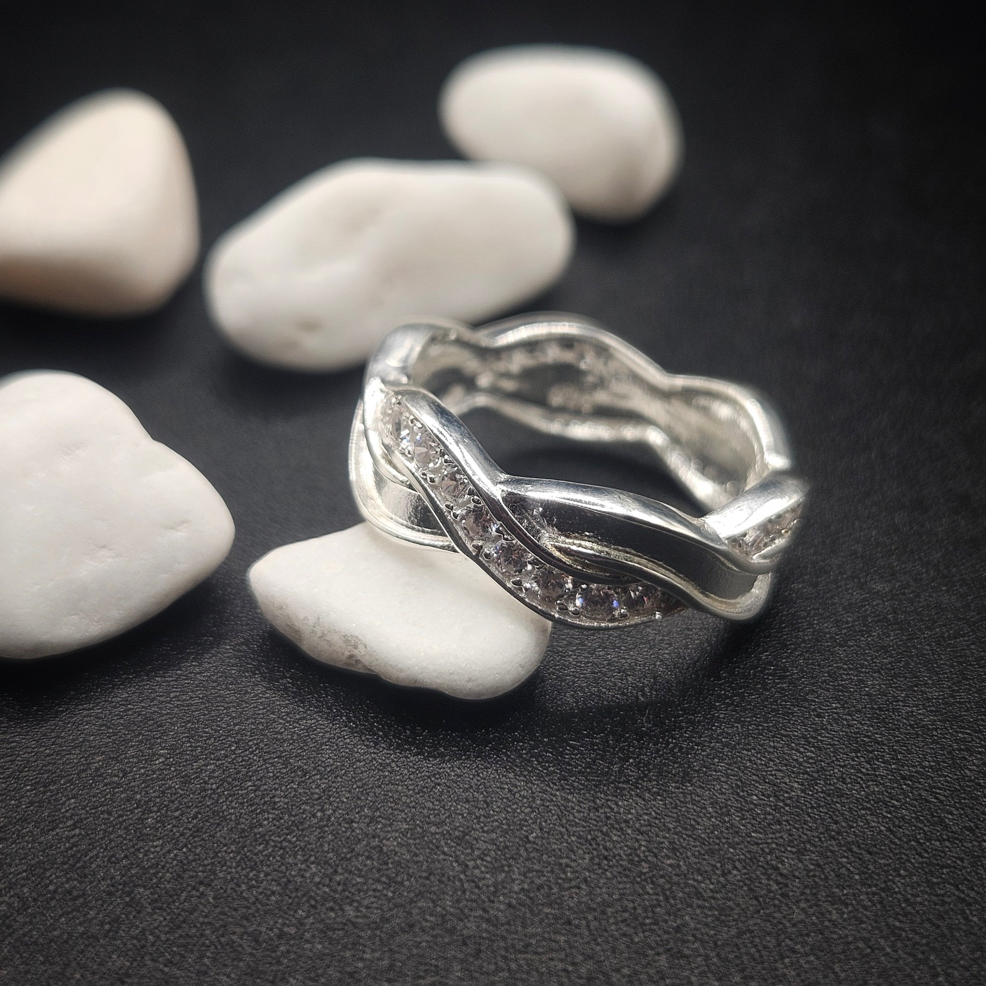 Silver ring with a textured design on pebbles