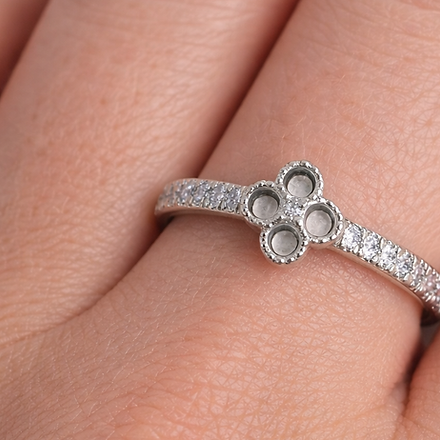 Silver ring with three circular stones on a finger