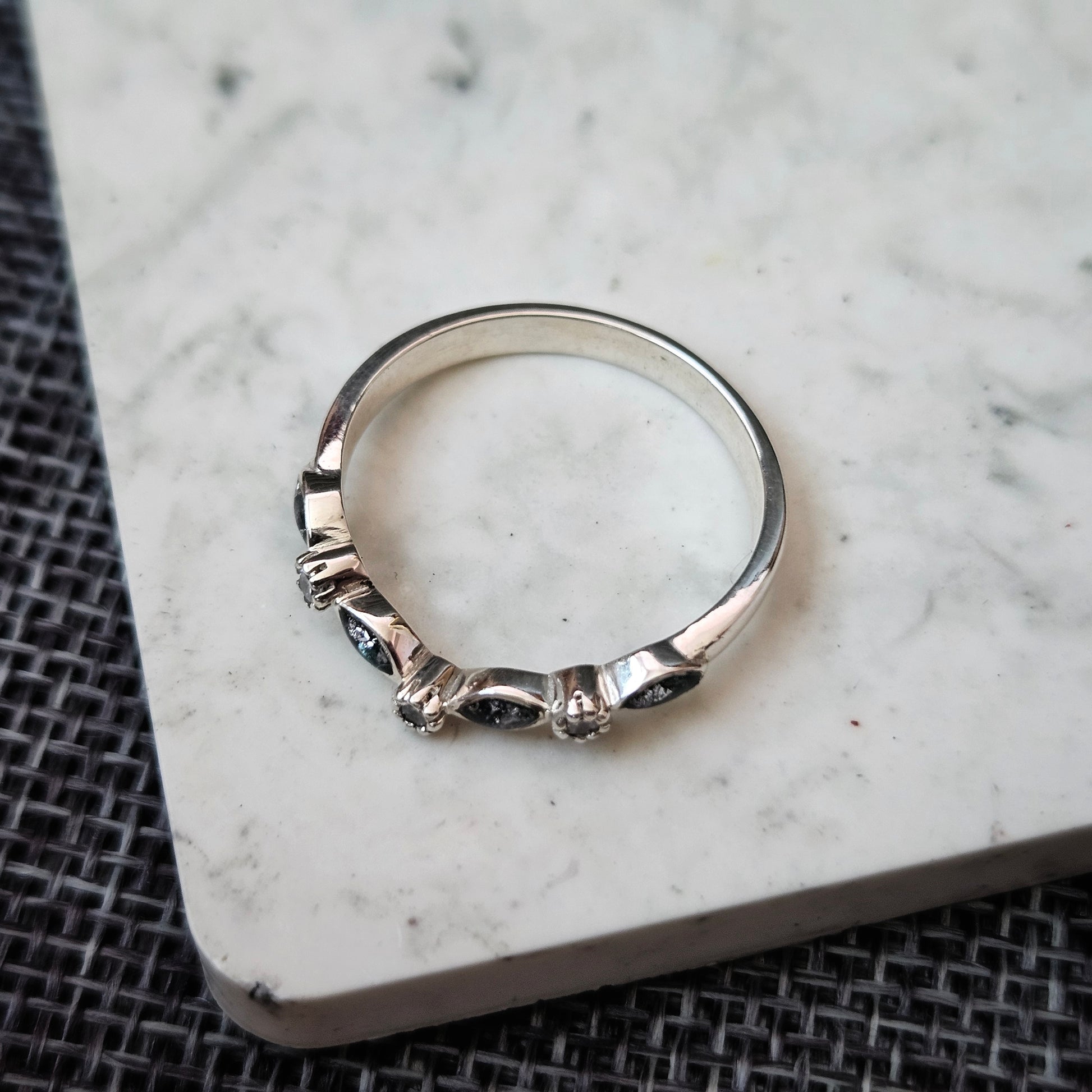 Silver ring with a unique design on a marble surface
