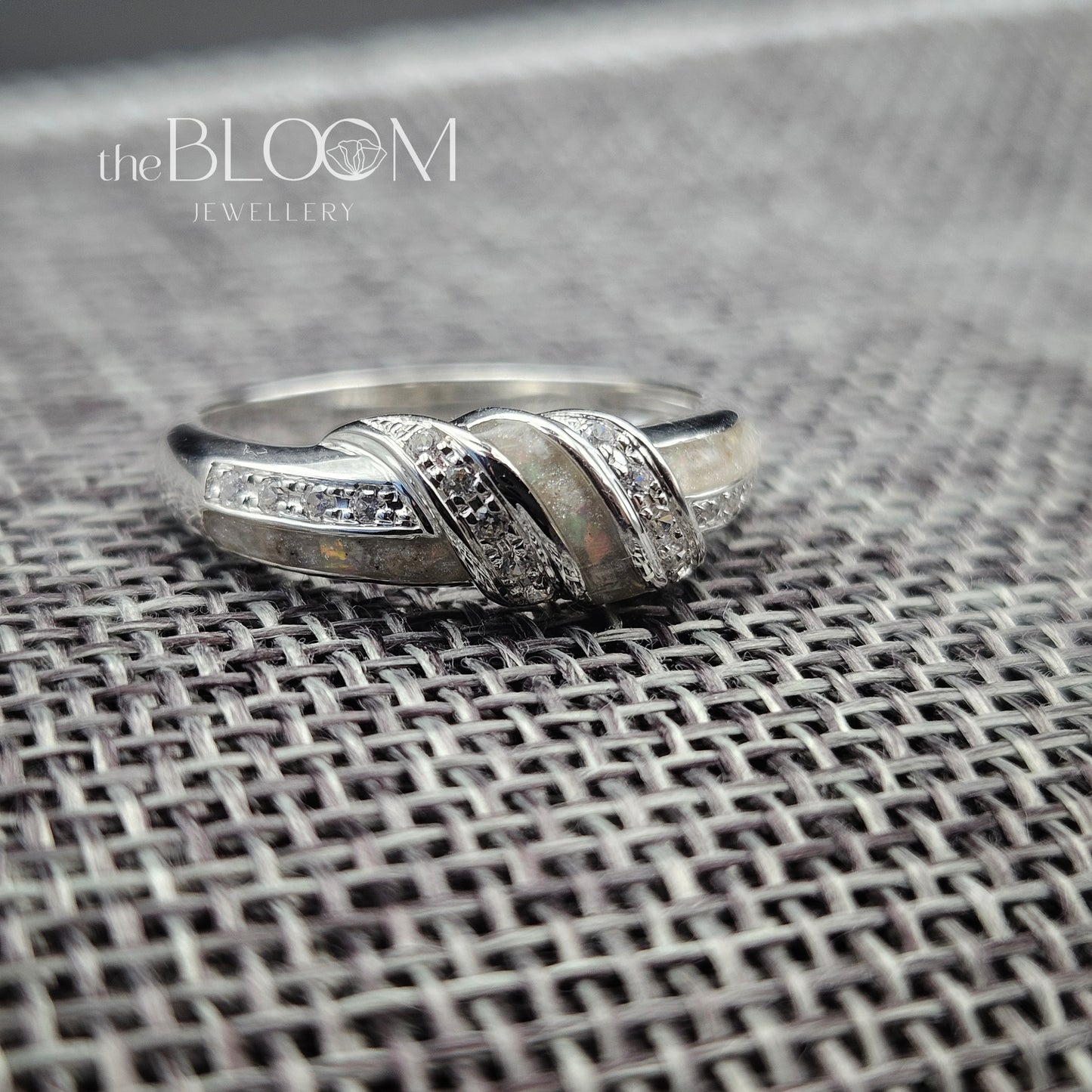 Silver ring with diamond accents on a textured surface, branded 'the BLOOM JEWELLERY'.