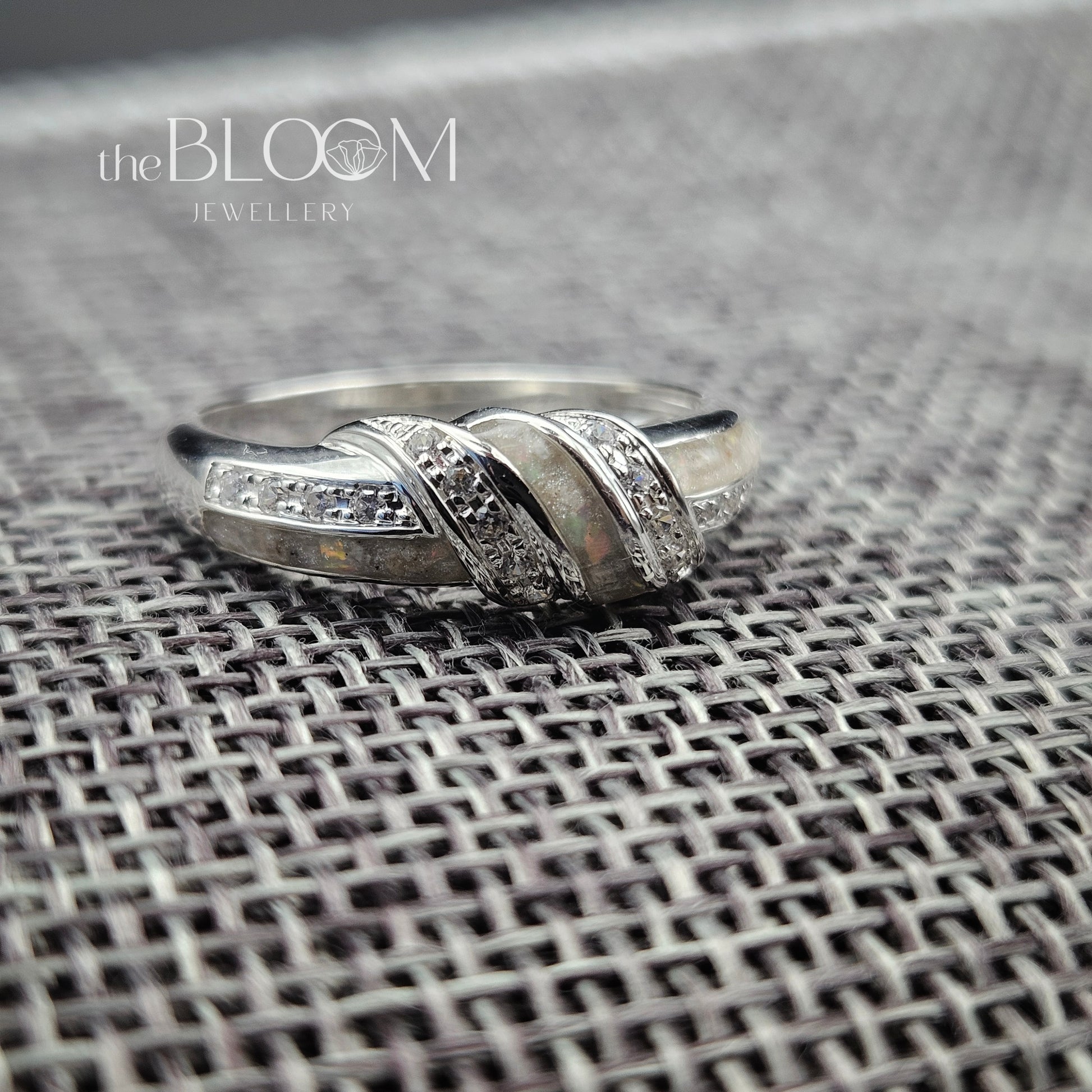 Silver ring with diamond accents on a textured surface, branded 'the BLOOM JEWELLERY'.
