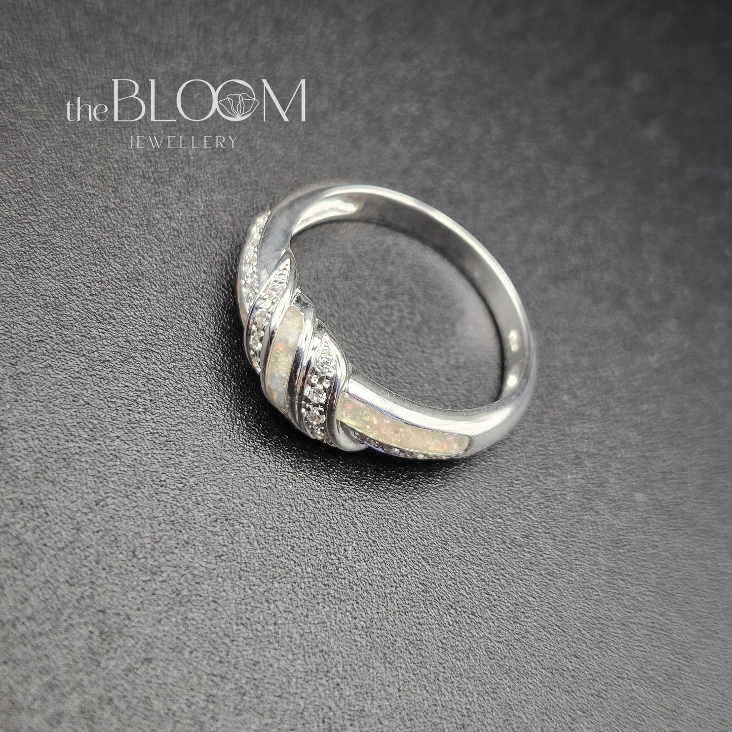Silver ring with intricate design on a gray background, branded 'the BLOOM Jewellery'.