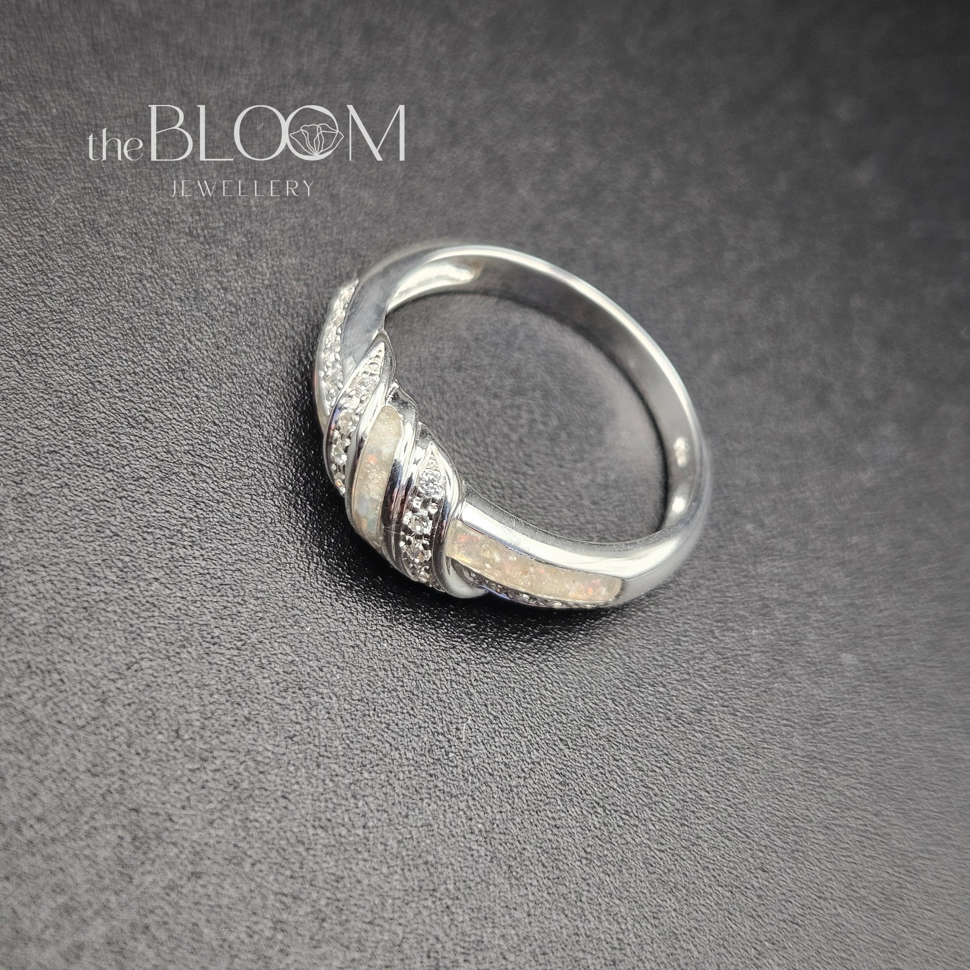 Silver ring with intricate design on a gray background, branded 'the BLOOM Jewellery'.