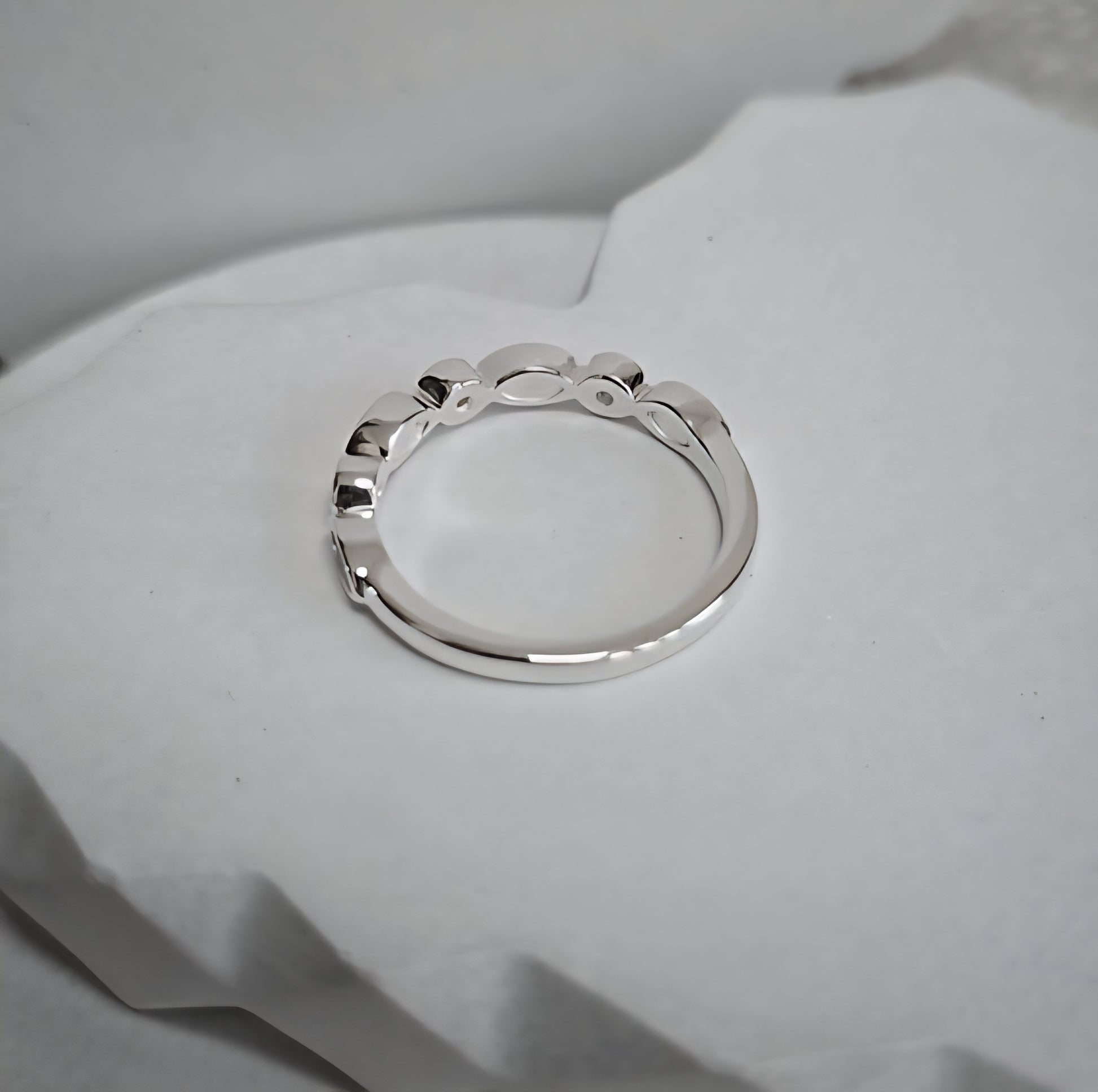 Silver ring on a soft white fabric background