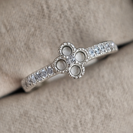 Silver ring with paw print design on a soft brown surface