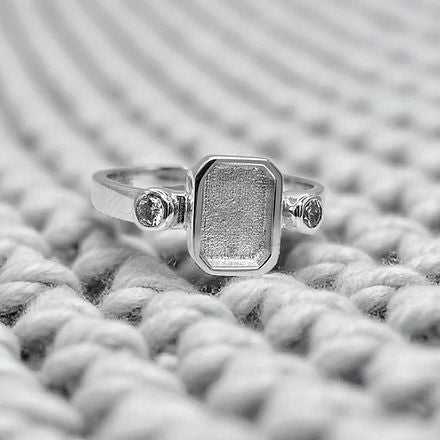 Silver ring with a textured band on a textured gray surface