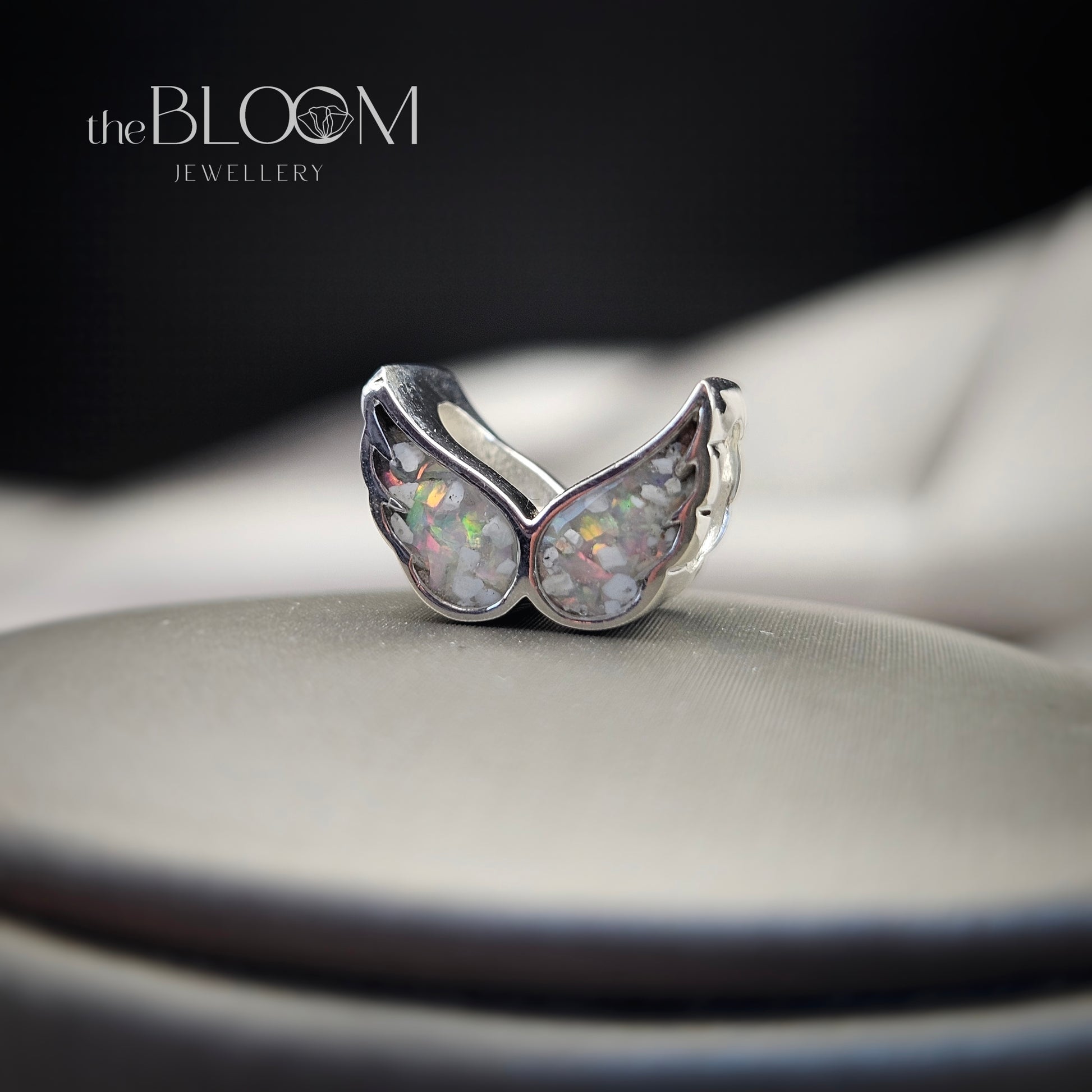 Silver ring with opal stones on a dark background, branded 'the BLOOM JEWELLERY'.