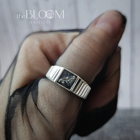 Silver ring on a finger with 'the BLOOM' branding in the corner.