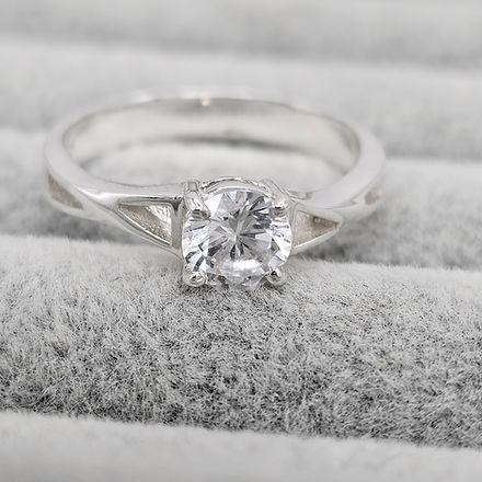 Silver ring with a diamond on a textured gray surface