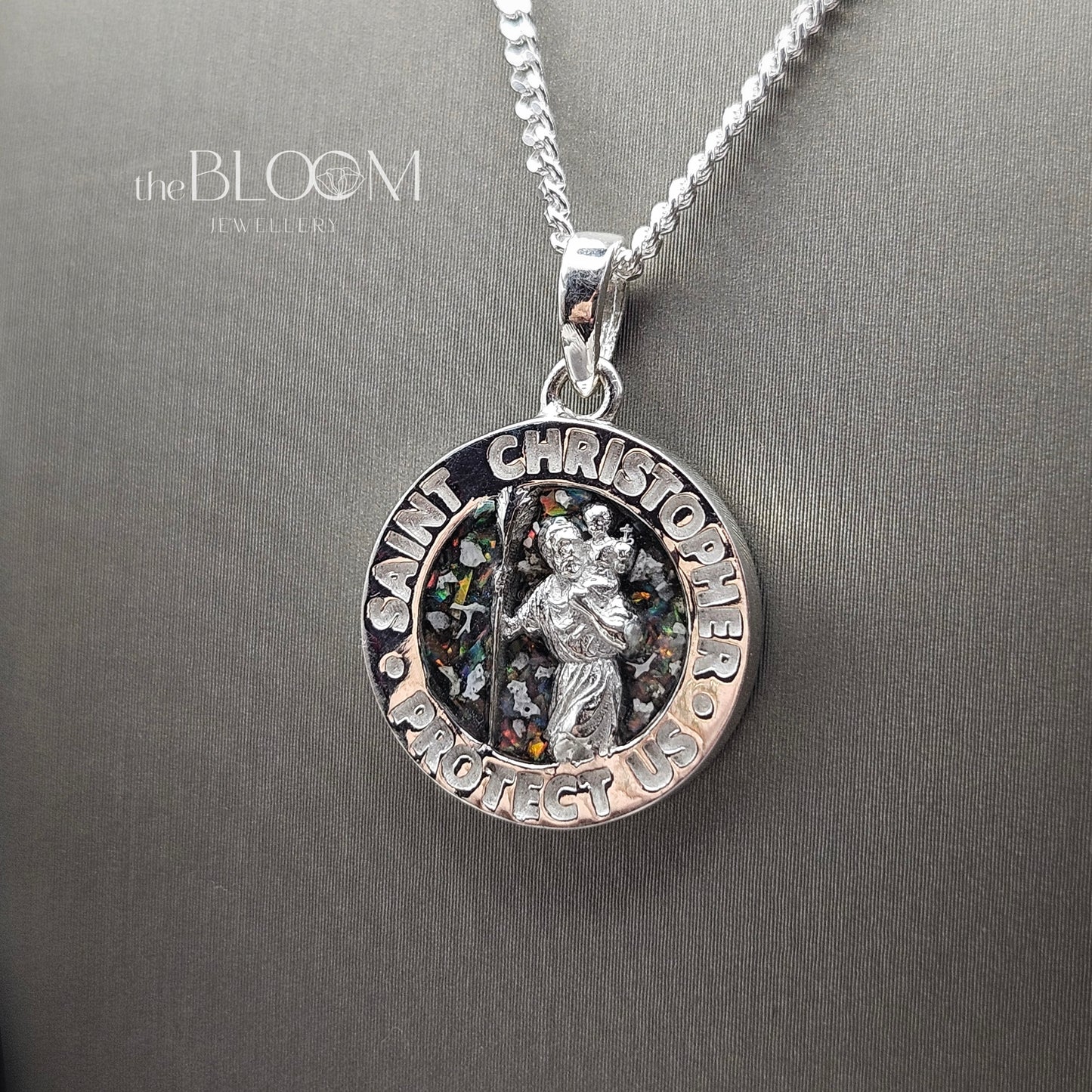 Silver Saint Christopher pendant on a chain against a gray background with 'the Bloom Jewellery' branding.