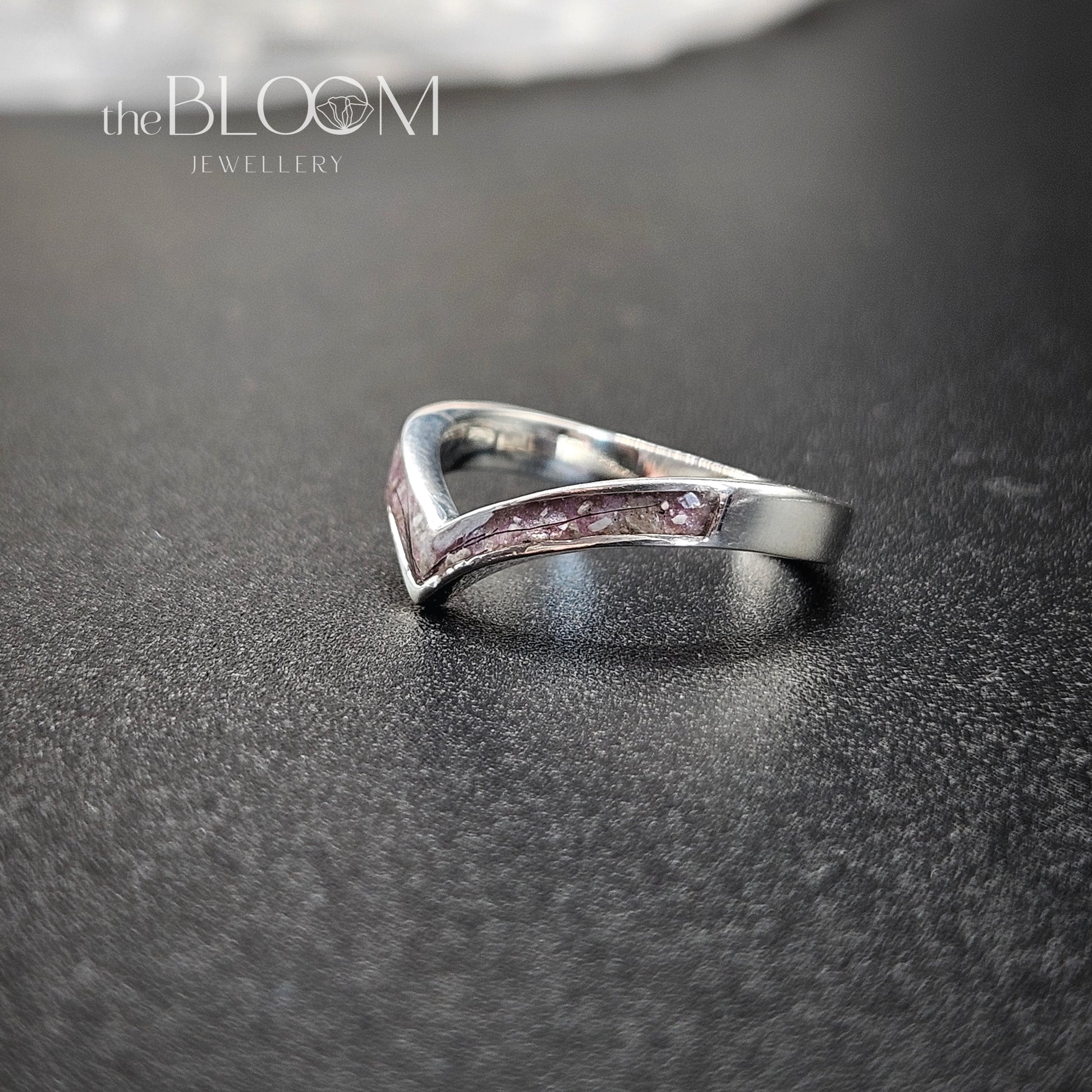 Silver ring on a dark textured surface with 'the BLOOM JEWELLERY' logo.